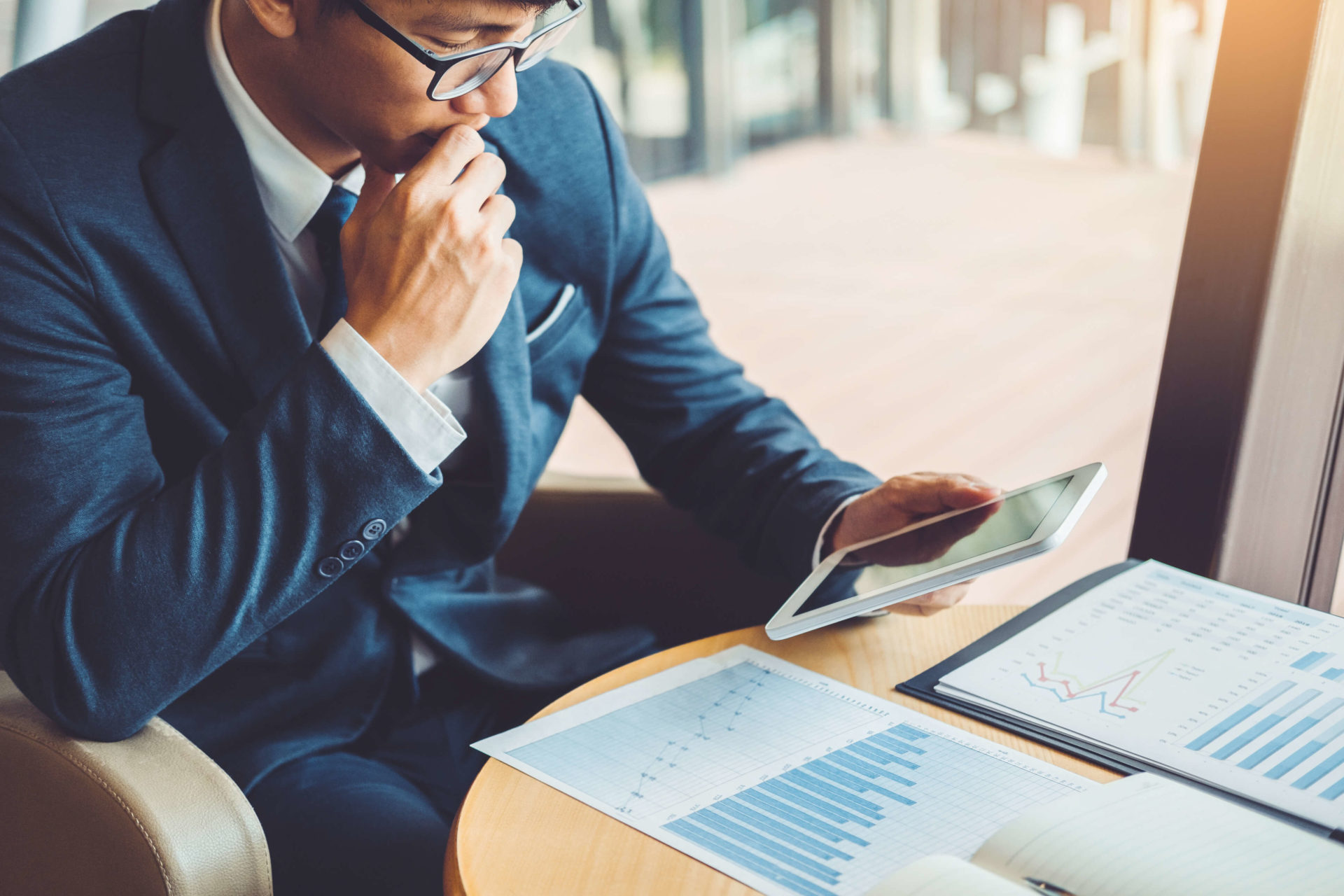man looking at graphs and tablet