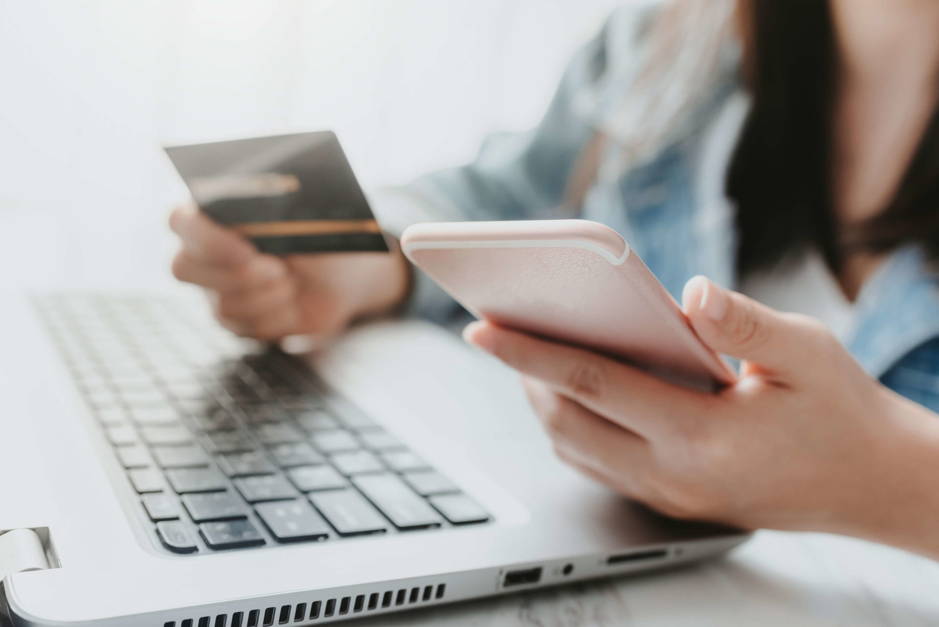person holding a phone and a credit card person holding a phone and a credit card