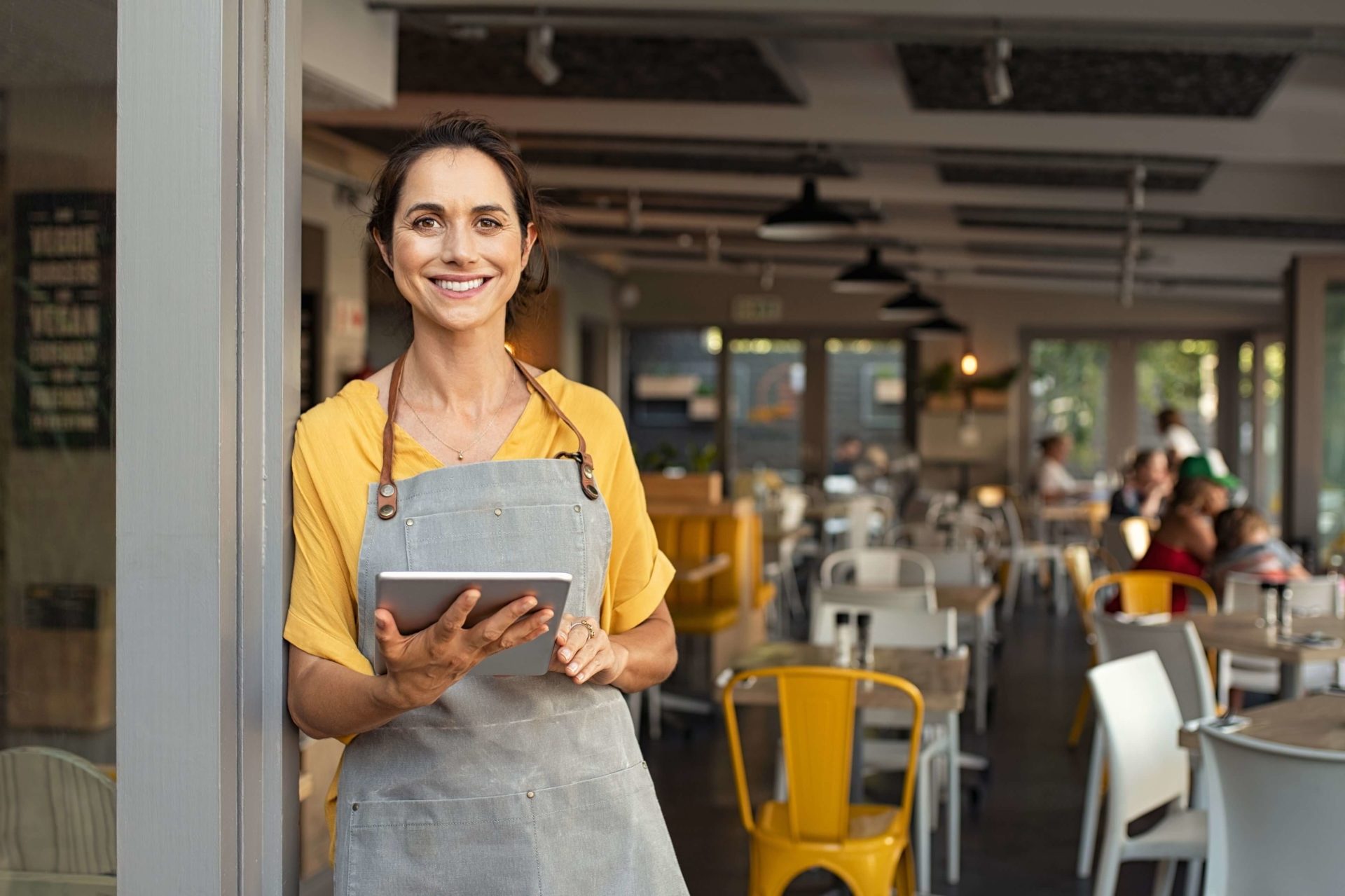 female cafe business owner holding ipad