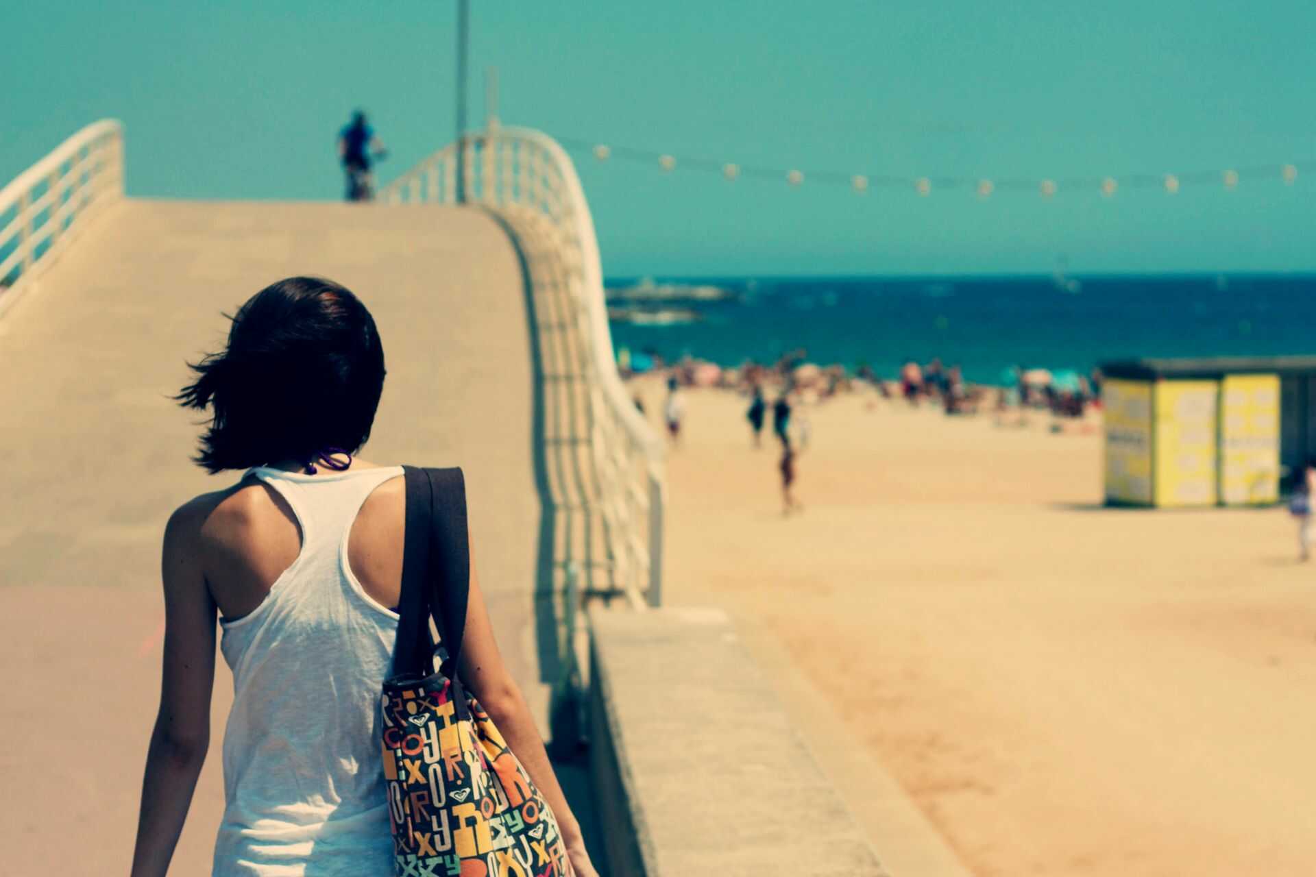 woman walking on beach pier